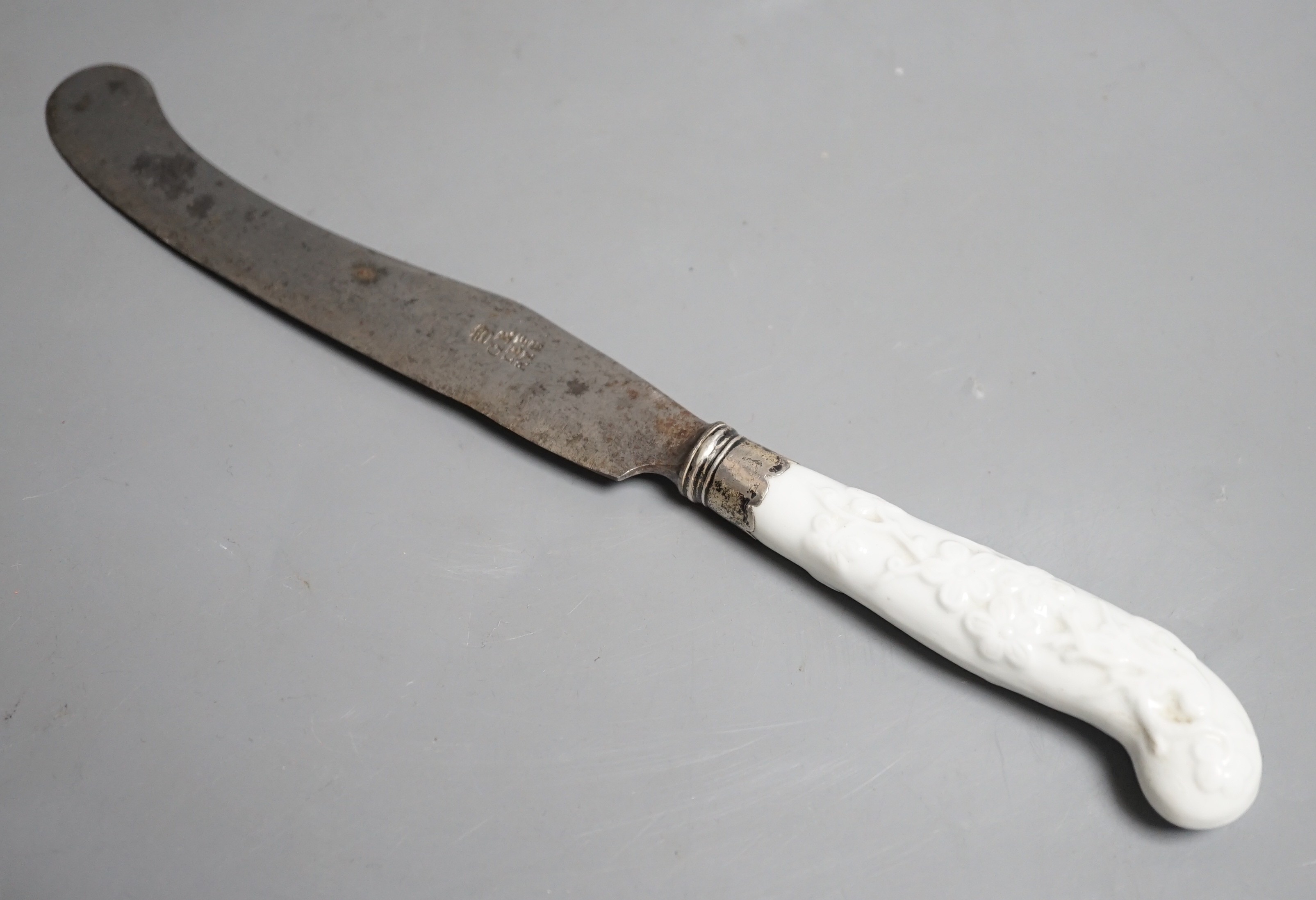 A Chelsea blanc de chine knife handle moulded with entwined branches and flowerheads, with silver ferule, incised triangle period
